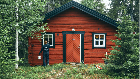 a man painting a wooden house